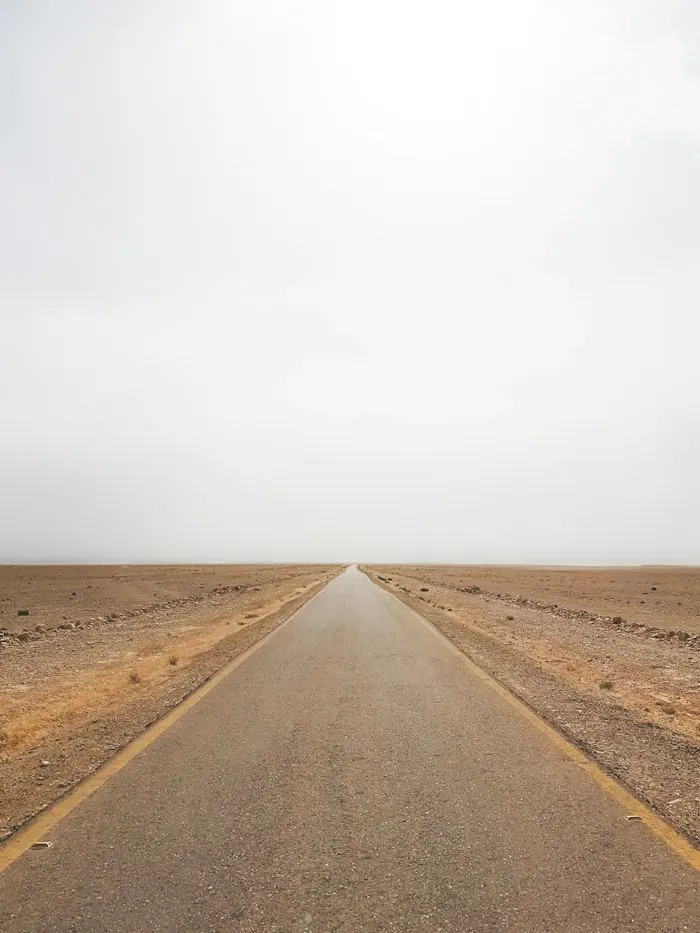 Placeholder: an empty road running into a flat desert